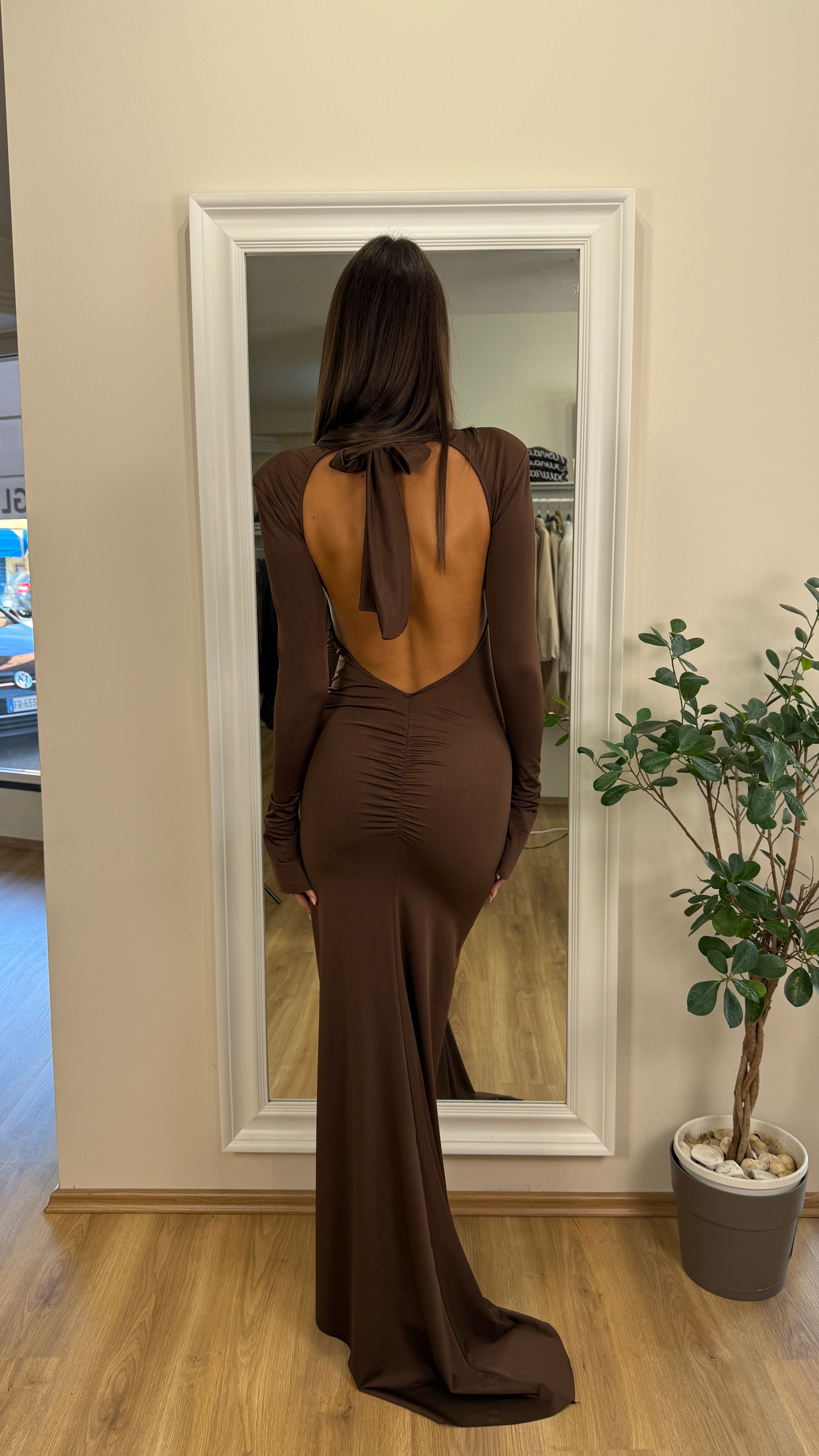 Abito a tubino con coda e schiena scoperta.