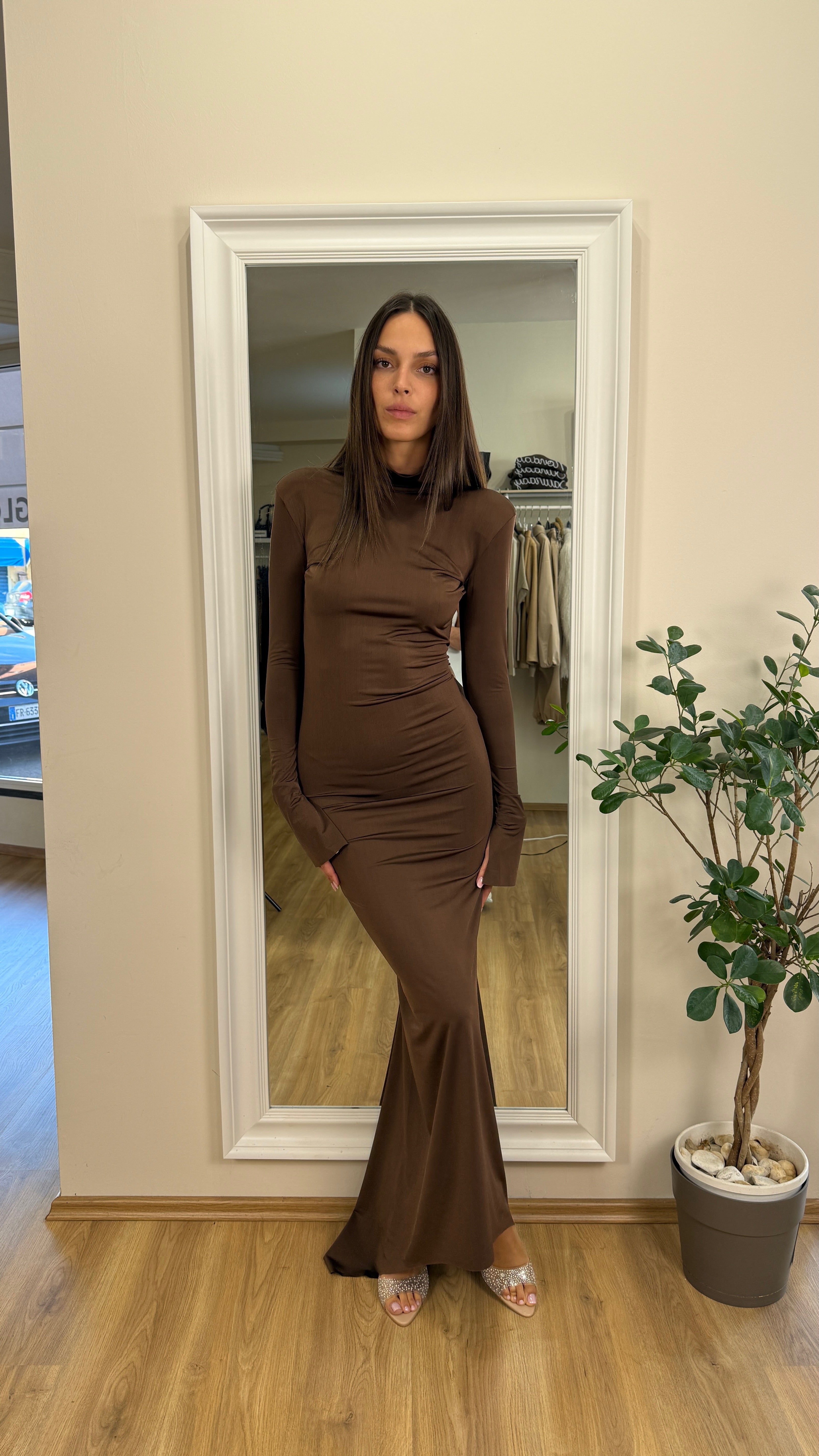 Abito a tubino con coda e schiena scoperta.