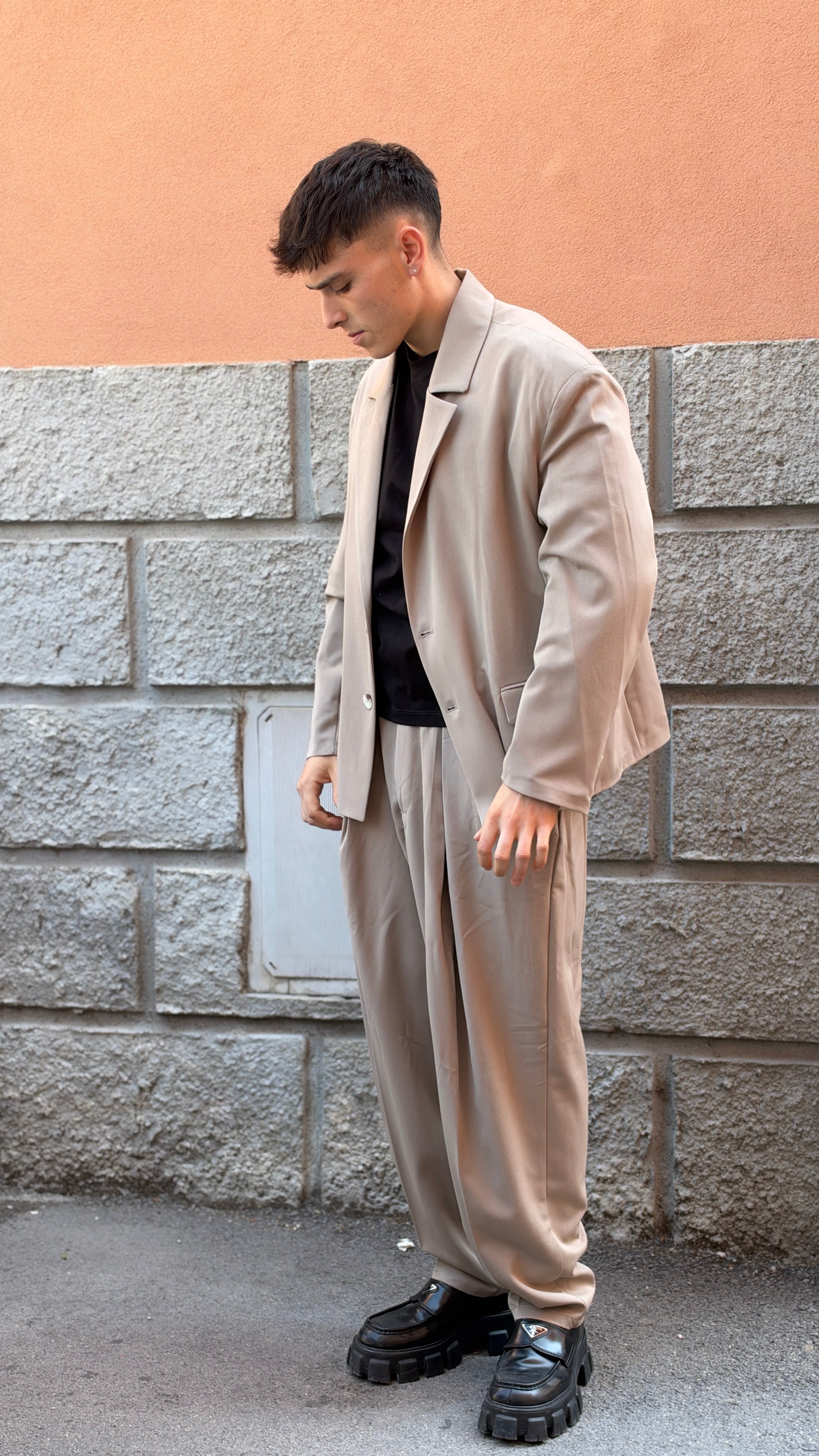 Tailleur beige con giacca crop e pantalone largo.
