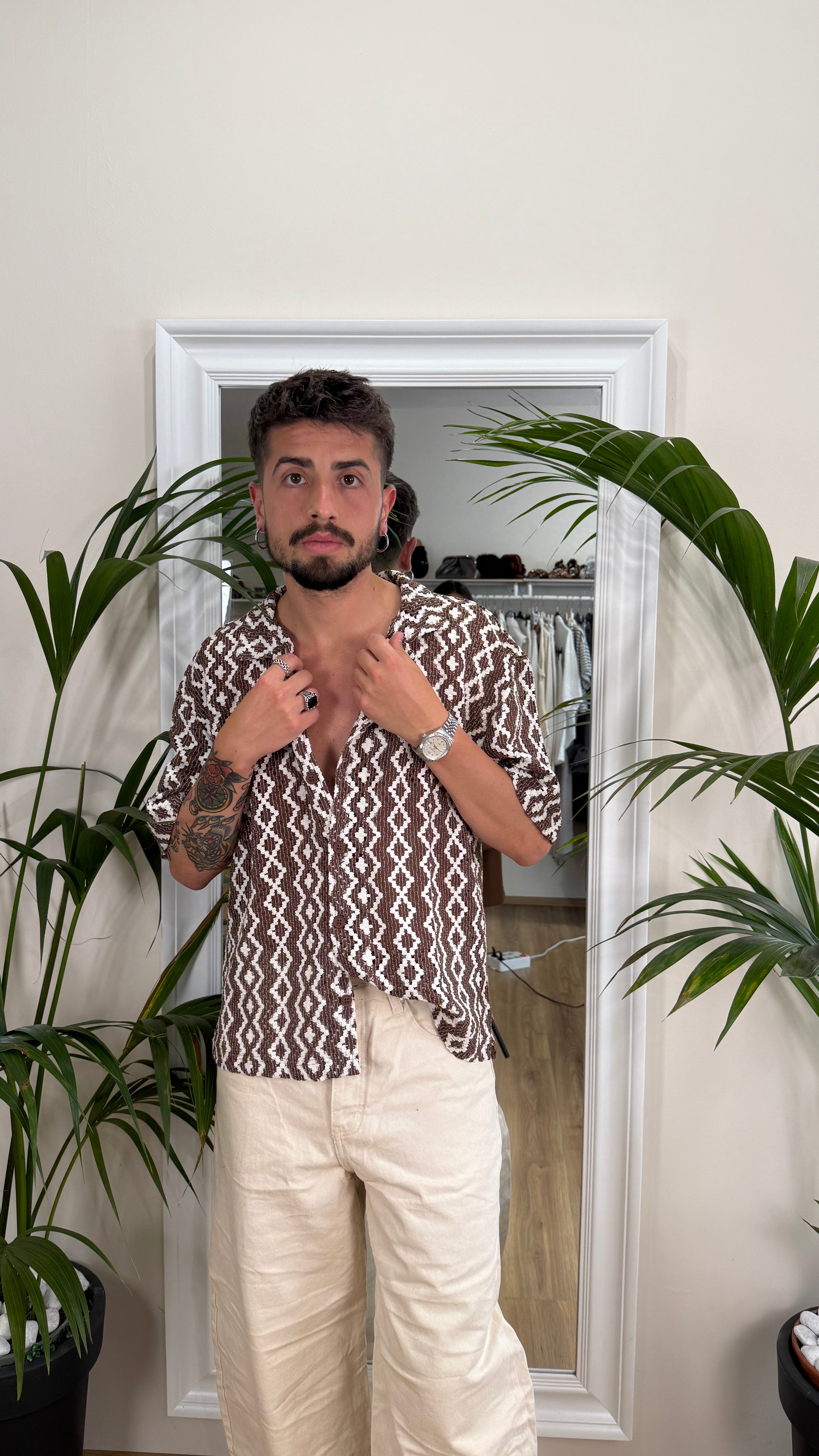 Camicia traforata bianca e marrone.